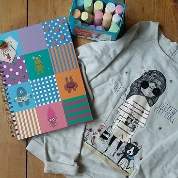 Picture of a notebook, pavement chalks and top I bought for my daughter from Hadleigh charity shops
