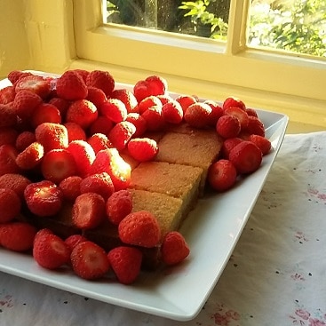 Picture of home-made banana cake piled high with Suffolk strawberries, using a quick and easy frugal recipe for banana cake to cut costs and cut food waste