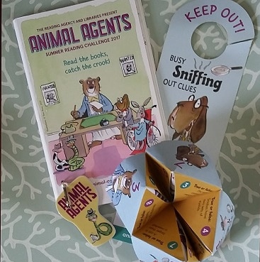 Photo of loot from the Animal Agents Summer Reading Challenge at our local library including a booklet, door sign, key ring and folding paper question and answer game, all completely free