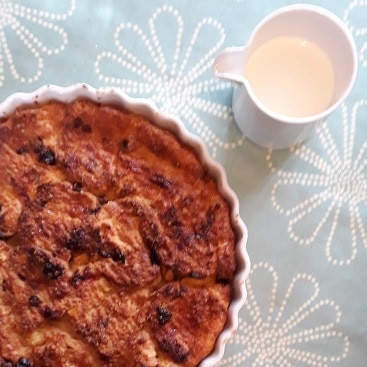 Picture of bread and butter pudding and cream for my post on cutting food costs in January
