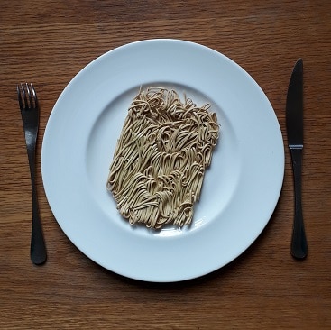 Picture of uncooked noodles on a plate with a knife and fork for my post about what parents need to know about student loans