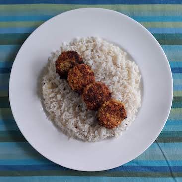 Picture of four falafel on a plate of boiled rice as one of my meals on the Ration Challenge