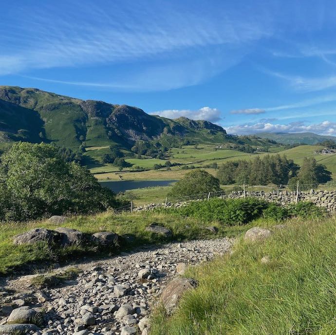 Picture of the Lake District Tilburthwaite walk with fells, trees, rocky path and blue sky
